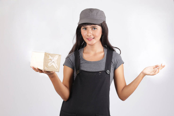 Ασιάτισσα πακέτο απομονωμένο. μεταφορά, ταχυδρομείο και οι άνθρωποι έννοια χαμογελώντας νεαρή γυναίκα κρατώντας κουτί - Φωτογραφία, εικόνα