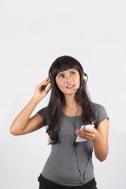 donna asiatica che ascolta musica con smartphone e cuffie. attraente asiatico ragazza orecchio musica su bianco sfondo. - Foto, immagini