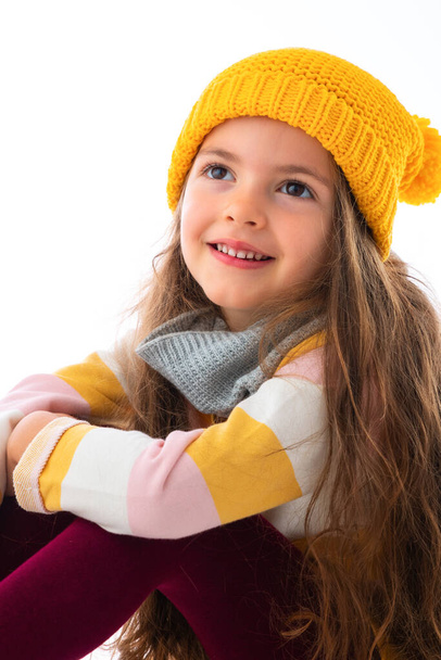 Menina bonita feliz com roupas coloridas posando em estúdio, retrato sobre fundo branco - Foto, Imagem