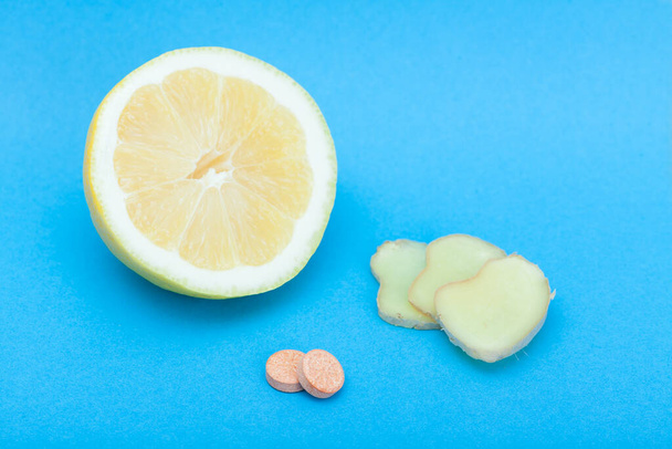 Lemon with ginger slices and pills and selective focus - Photo, image