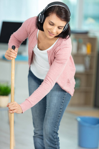 happy woman in headphones with mop and bucket cleaning floor - Photo, Image