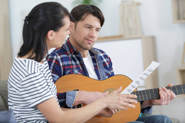 music playing lesson lovers couple at living room - Foto, Imagen