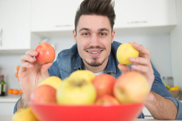 man holding two varieties of apple - Фото, зображення