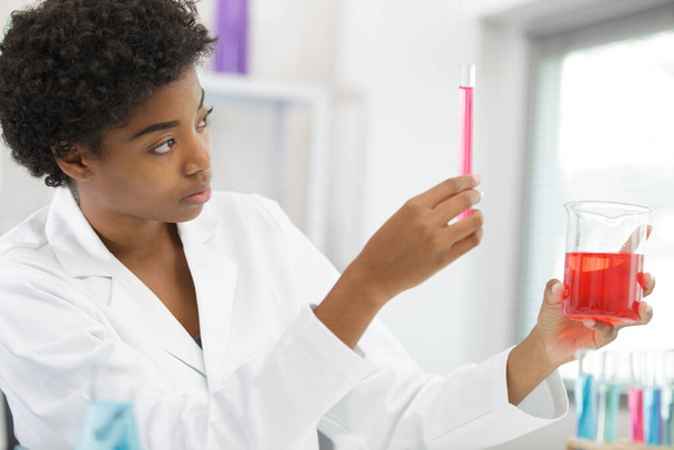 женщина-ученый в лаборатории делает химические тесты - Фото, изображение