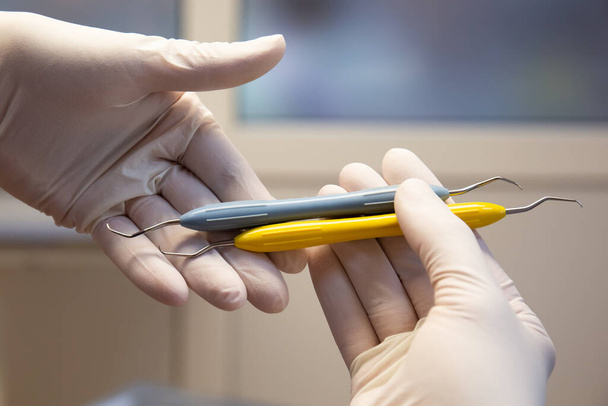 Hammaslääkärin työkalut asetettu hoitoon hampaita käsissä - Valokuva, kuva