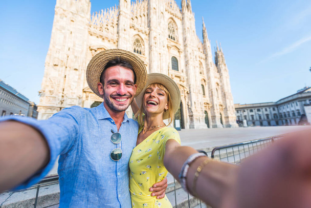Beautiful couple of lovers sightseeing in Italy - Playful tourists visiting the Duomo cathedral in Milan - Foto, Bild