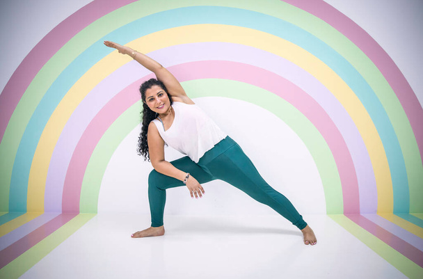 молода жінка в позі йоги в барвистій кімнаті
 - Фото, зображення