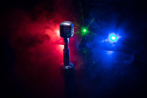 Microfone estilo retro no fundo com luz de fundo. Microfone de prata vintage para som, música, karaoke. Equipamento de transmissão de voz. Pop ao vivo, performance musical de rock. Foco seletivo - Foto, Imagem
