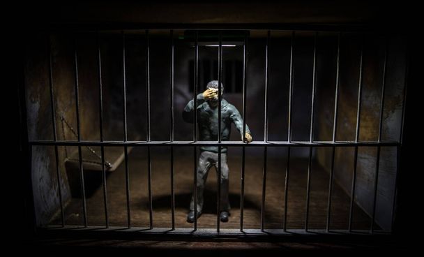 L'uomo in prigione dietro le sbarre. Vecchio sporco grunge prigione in miniatura. prigione oscura decorazione creativa interiore. Focus selettivo - Foto, immagini
