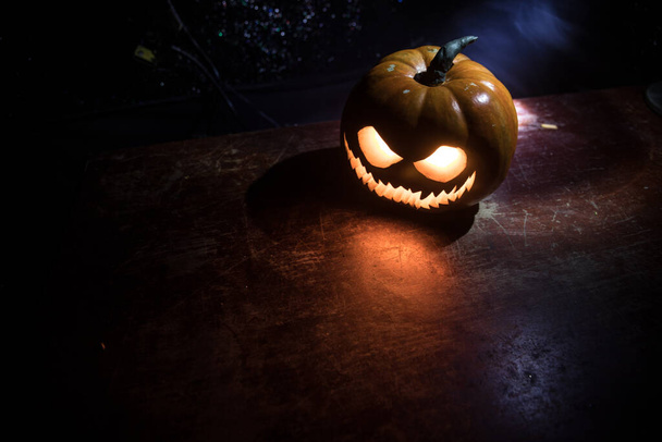 Halloween dyniowy uśmiech i przerażające oczy na noc party. Zamknij widok przerażający Halloween dyni z oczami świecącymi wewnątrz na czarnym tle. Skupienie selektywne - Zdjęcie, obraz
