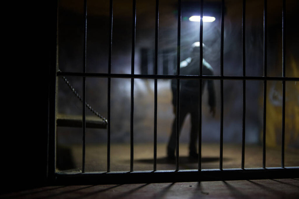 刑務所の男バーのコンセプトの後ろに男。古い汚いグランジ刑務所のミニチュア。ダーク刑務所内部の創造的な装飾。選択的焦点 - 写真・画像
