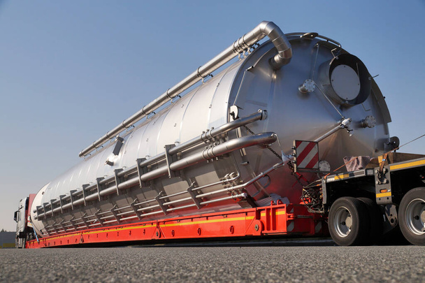 Ciężarówka ze specjalną naczepą do przewozu ładunków ponadgabarytowych. Nadmierne obciążenie lub wyjątkowy konwój.  - Zdjęcie, obraz