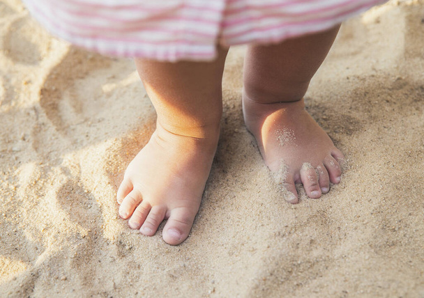 little baby feet of a child who walks along the seashore - Photo, Image