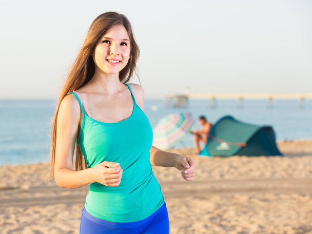 Female in blue T-shirt is jogging - Zdjęcie, obraz