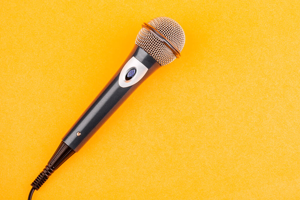 Akustisches Mikrofon auf gelbem Hintergrund. Der Blick von oben. - Foto, Bild