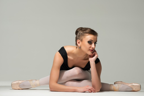 Belle jeune danseuse de ballerine assise sur un sol
 - Photo, image