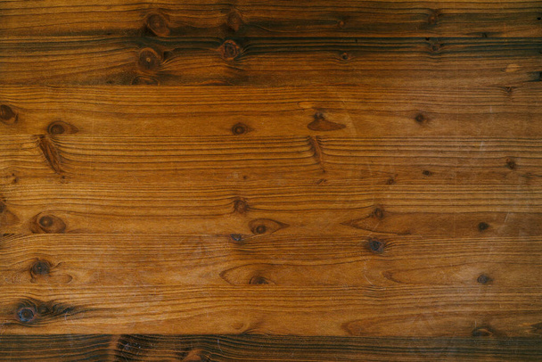 Uma textura close-up de uma superfície de madeira marrom, com padrões de anéis e galhos anuais. - Foto, Imagem