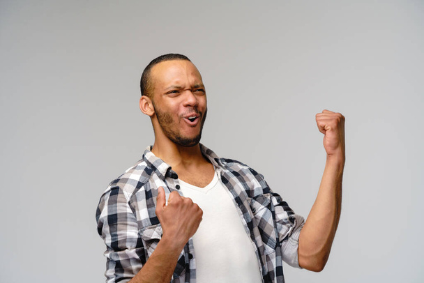 Young African-American man yes win gesturing over light grey background - Photo, Image