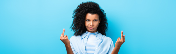 δυσαρεστημένη Αφροαμερικανή που δείχνει μεσαία δάχτυλα στο μπλε, λάβαρο - Φωτογραφία, εικόνα