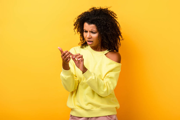 elégedetlen afro-amerikai nő nézi ujjak sárga - Fotó, kép