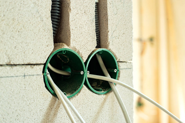 Новая электропроводка, пластиковые коробки и электрические кабели для будущих розетки на стене, концепция реконструкции. - Фото, изображение