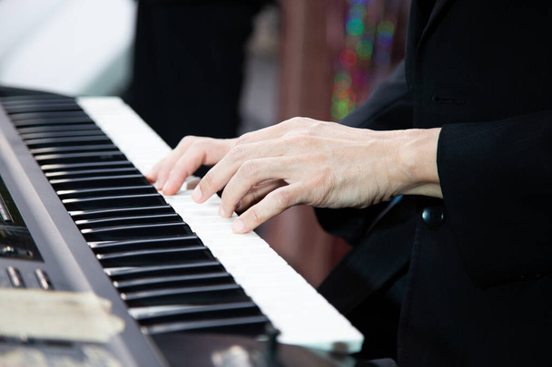 Крупный план руки музыкального исполнителя, играющего на пианино - Фото, изображение