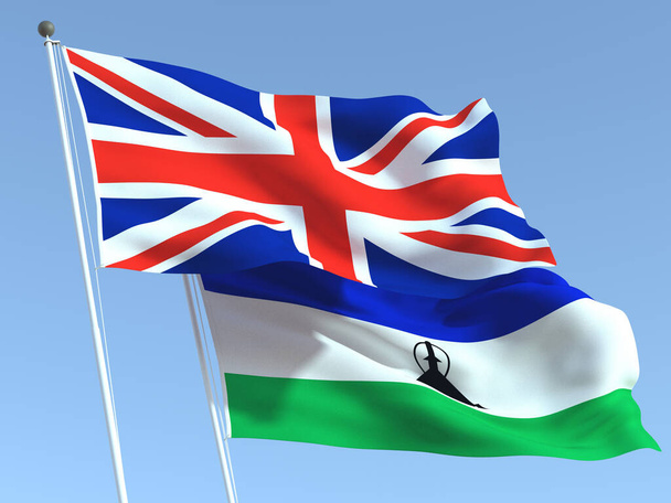 Два махаючих державні прапори Сполученого Королівства і Лесото на синьому небі. Високоякісне ділове минуле. 3d ілюстрація - Фото, зображення