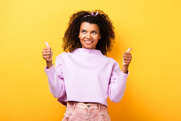 happy african american woman showing thumbs up on yellow - Photo, Image