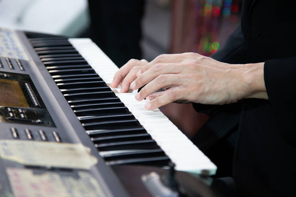 Close-up van de hand van een muziekartiest die piano speelt - Foto, afbeelding