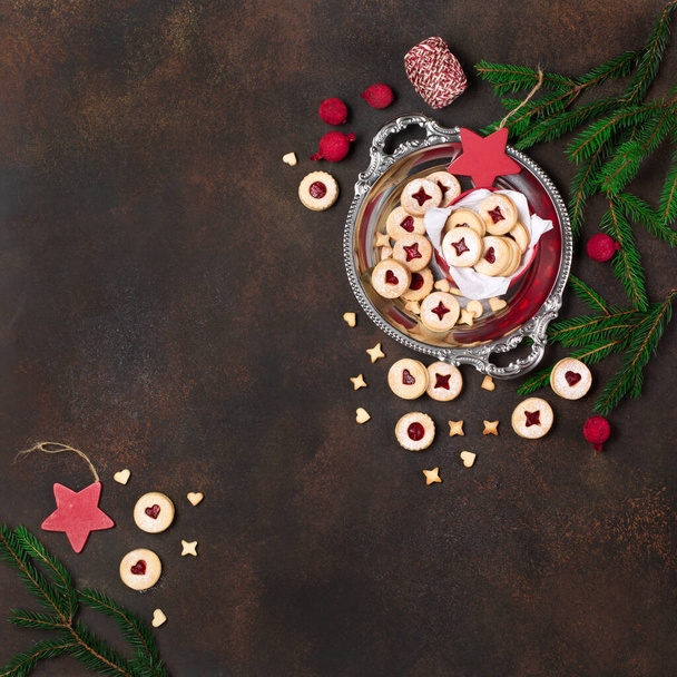 Печиво Linzer Christmas або New Year cookie наповнене джемом і насичене цукром на темному тлі. Традиційне австрійське різдвяне печиво. Мило присутнє у святковій коробці. Краєвид. - Фото, зображення