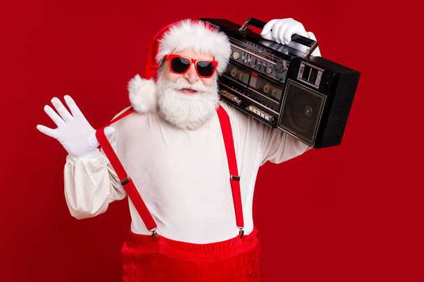 Portrait of his he handsome cool confident bearded Santa dj deejay hipster carrying retro tape boombox having fun rest relax chill celebratory isolated bright vivid shine vibrant red color background - Foto, Imagen