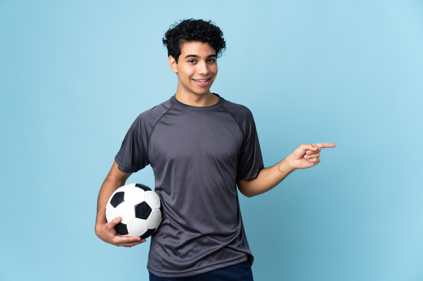 Venezuelan football player man over isolated background pointing finger to the side - Photo, Image