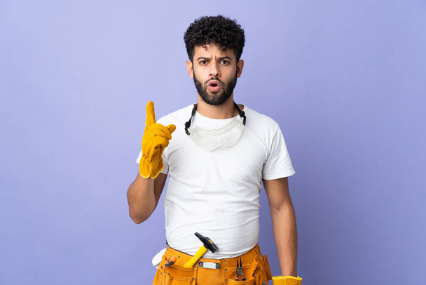 Young electrician Moroccan man isolated on purple background intending to realizes the solution while lifting a finger up - Foto, Bild