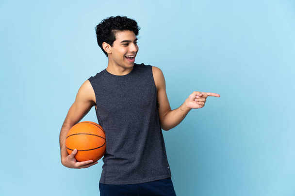 venezuelano jogador de basquete homem sobre fundo isolado apontando dedo para o lado e apresentando um produto - Foto, Imagem