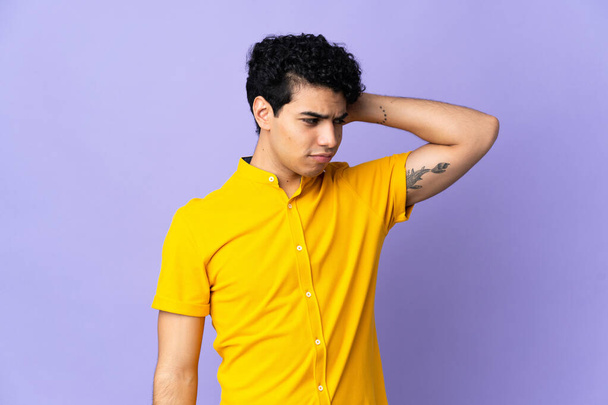Young Venezuelan man isolated on purple background having doubts while scratching head - Photo, Image