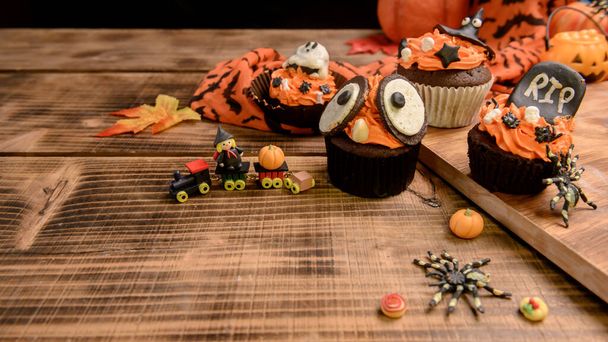 Koken heerlijke zelfgemaakte taart en versieren cupcake voor Halloween feestelijk. Zoet dessert en decoratie voor feest thuis. - Foto, afbeelding