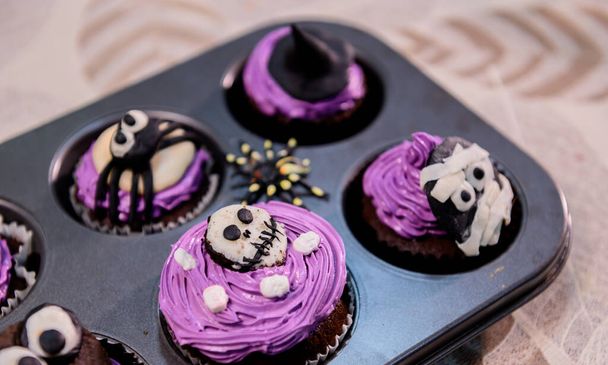 Cocinar delicioso pastel casero y decorar cupcake para Halloween festivo. Preparación y mezcla de ingredientes para el postre de alimentos dulces en la cocina en casa. - Foto, Imagen