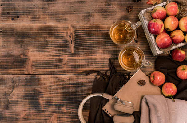 Φρέσκος χυμός με βιολογικά ώριμα κόκκινα μήλα σε ξύλινο κουτί. Φθινοπωρινή σοδειά καλαμποκιού το φθινόπωρο. Ποτό και φρούτα με φόντο ξύλινο τραπέζι. - Φωτογραφία, εικόνα