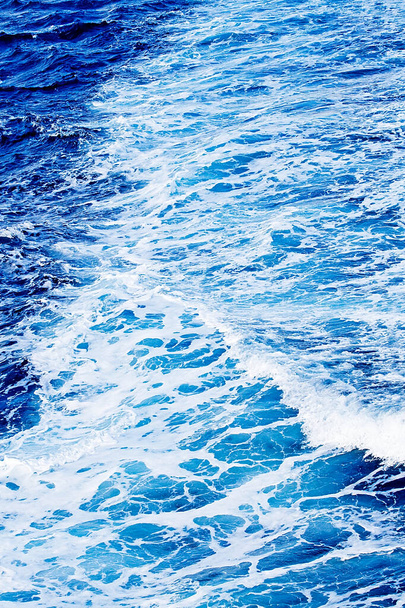 Coastal cliffs. Deep blue sea water. Sea waves with white foam and spray.  Coast of the Mediterranean Sea. Rhodes, Greece. Stock Photo