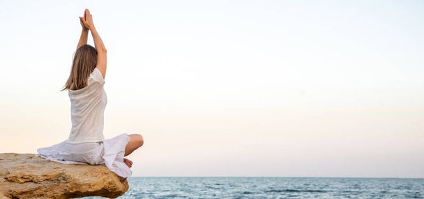 Woman meditating at the sea - Фото, зображення