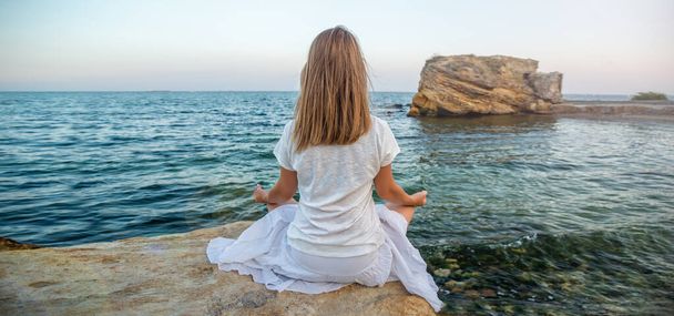 Woman meditating at the sea - Zdjęcie, obraz
