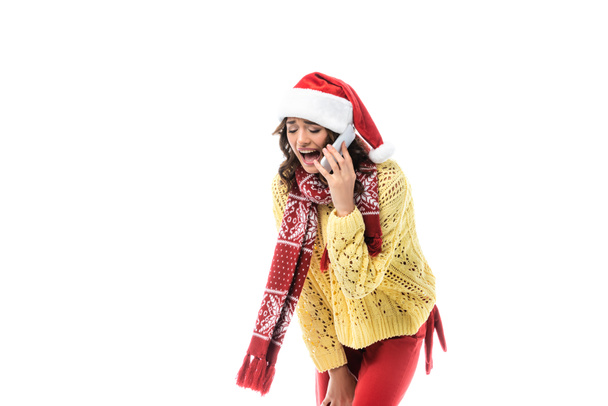 boos jonge vrouw in santa hoed en sjaal schreeuwen terwijl het praten op smartphone geïsoleerd op wit  - Foto, afbeelding