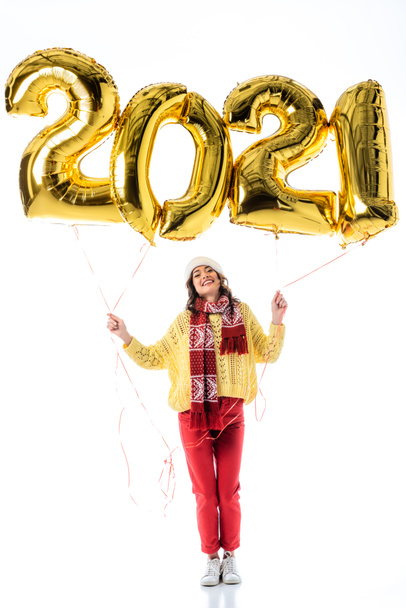 zadowolona kobieta w Santa kapelusz i szalik gospodarstwa balony z 2021 numery izolowane na białym - Zdjęcie, obraz