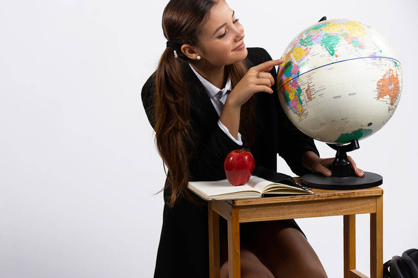 Student girl searching country on globe. Teenager at the geography leeson with beautiful smile isolated white background - Foto, Bild