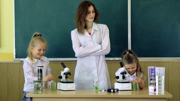 Schüler und Lehrer benutzen Mikroskope im naturwissenschaftlichen Unterricht. Zurück in die Schule und nach Hause. - Filmmaterial, Video