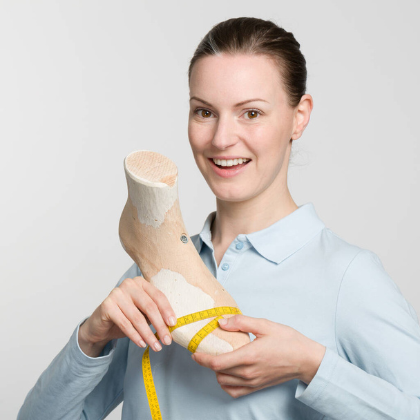 orgulhoso sapateiro ortopédico feminino verificando medidas de um artesanal de madeira última - Foto, Imagem