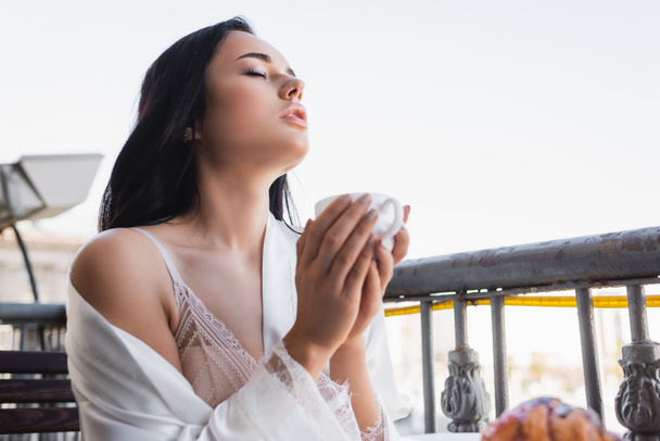 schöne brünette Frau genießt Kaffee trinken mit geschlossenen Augen - Foto, Bild