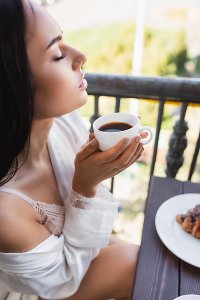 beautiful brunette woman enjoying drinking coffee with closed eyes - Фото, зображення