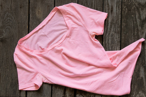 ροζ γυναικεία t-shirt επίπεδη θέσει σε ρουστίκ καφέ φόντο, γυναικεία ρούχα, μόδα - Φωτογραφία, εικόνα
