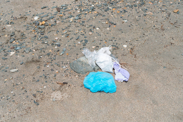 Resíduos médicos, máscara facial descartada lixo, crianças brincam na praia do mar, poluição pandêmica pelo vírus COVID-19 - Foto, Imagem